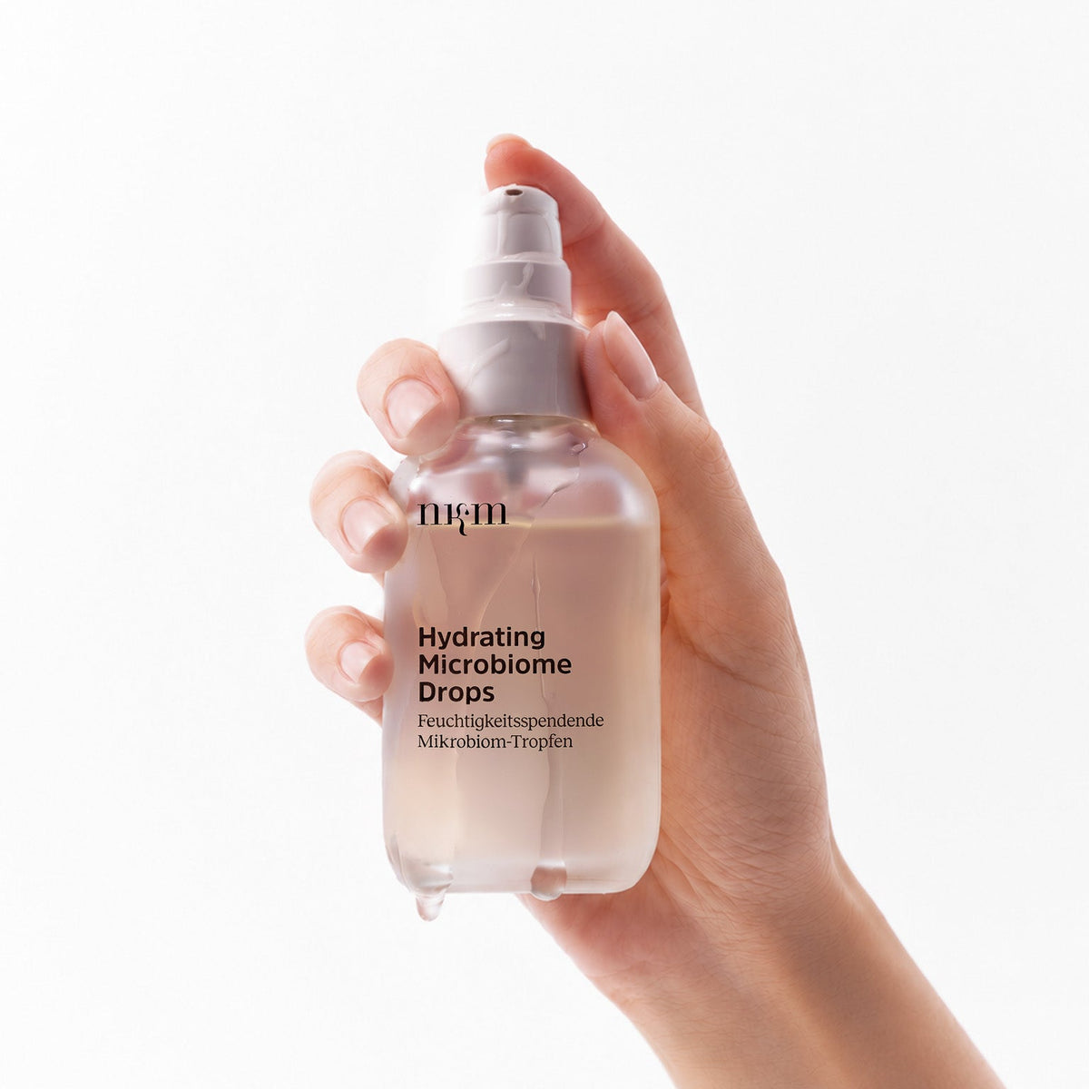 Hand hält die Hydrating Microbiome Drops von nkm
