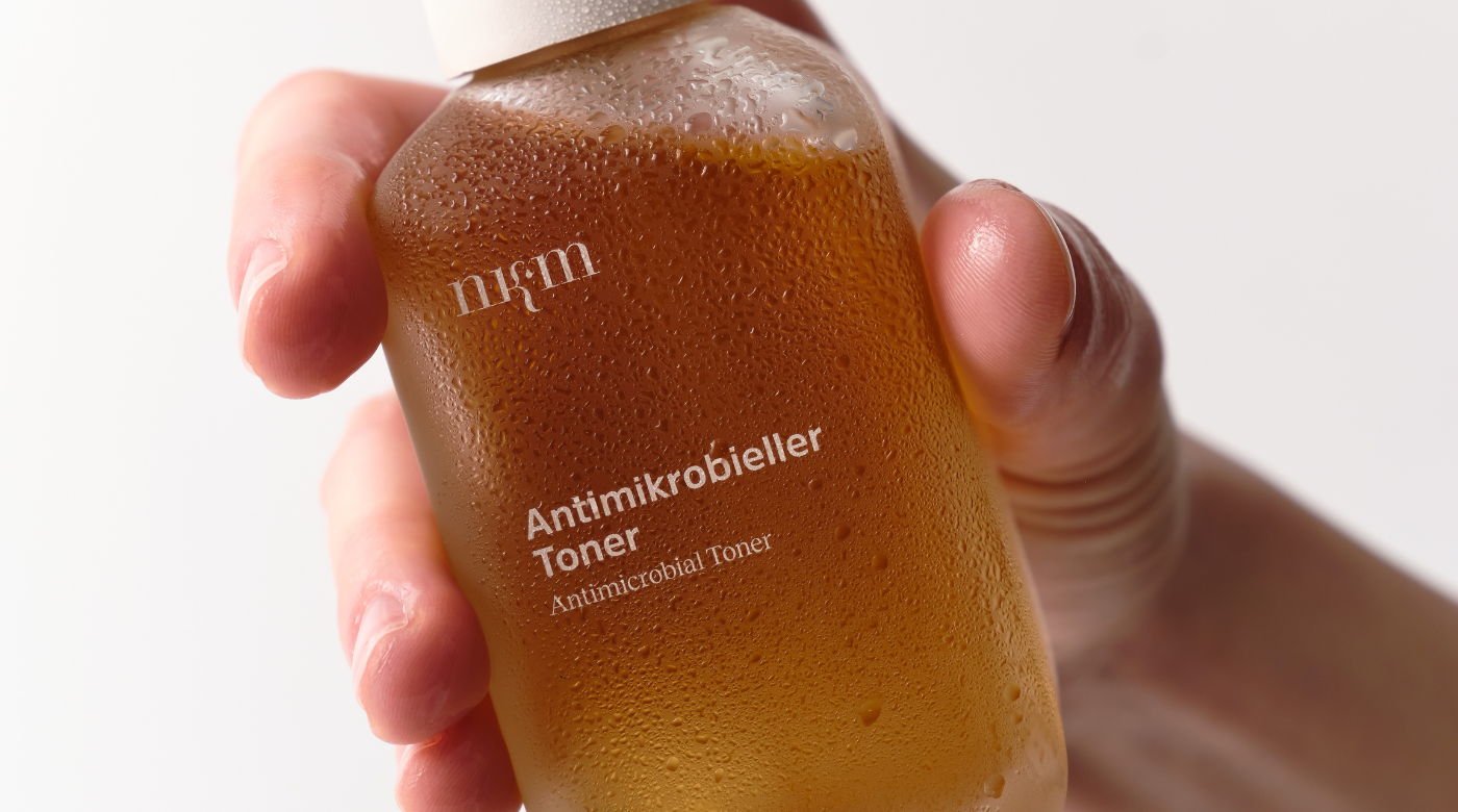 Hand hält den Antimikrobiellen Toner
