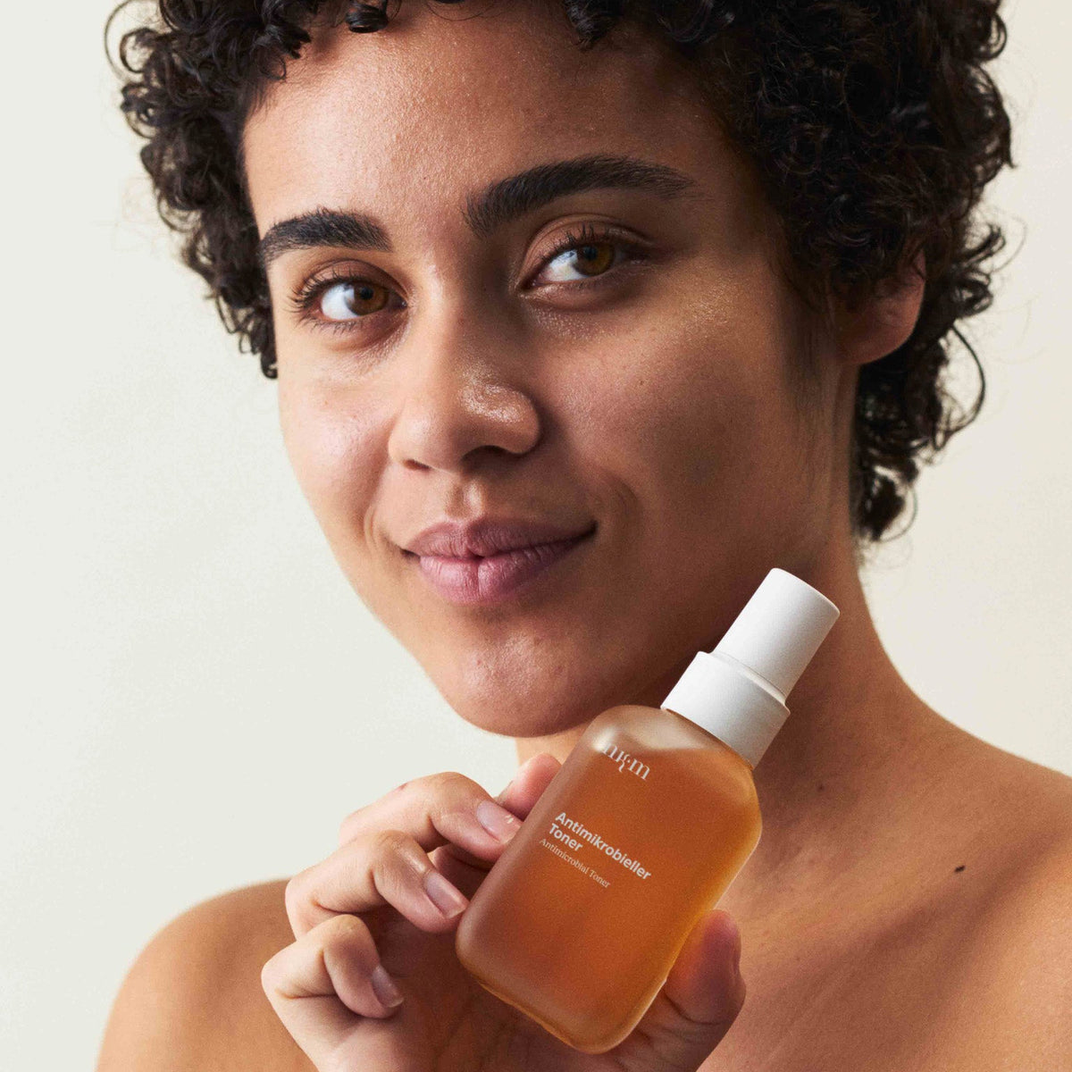 Eine Frau, die den Antimikrobiellen Toner der Hand hält