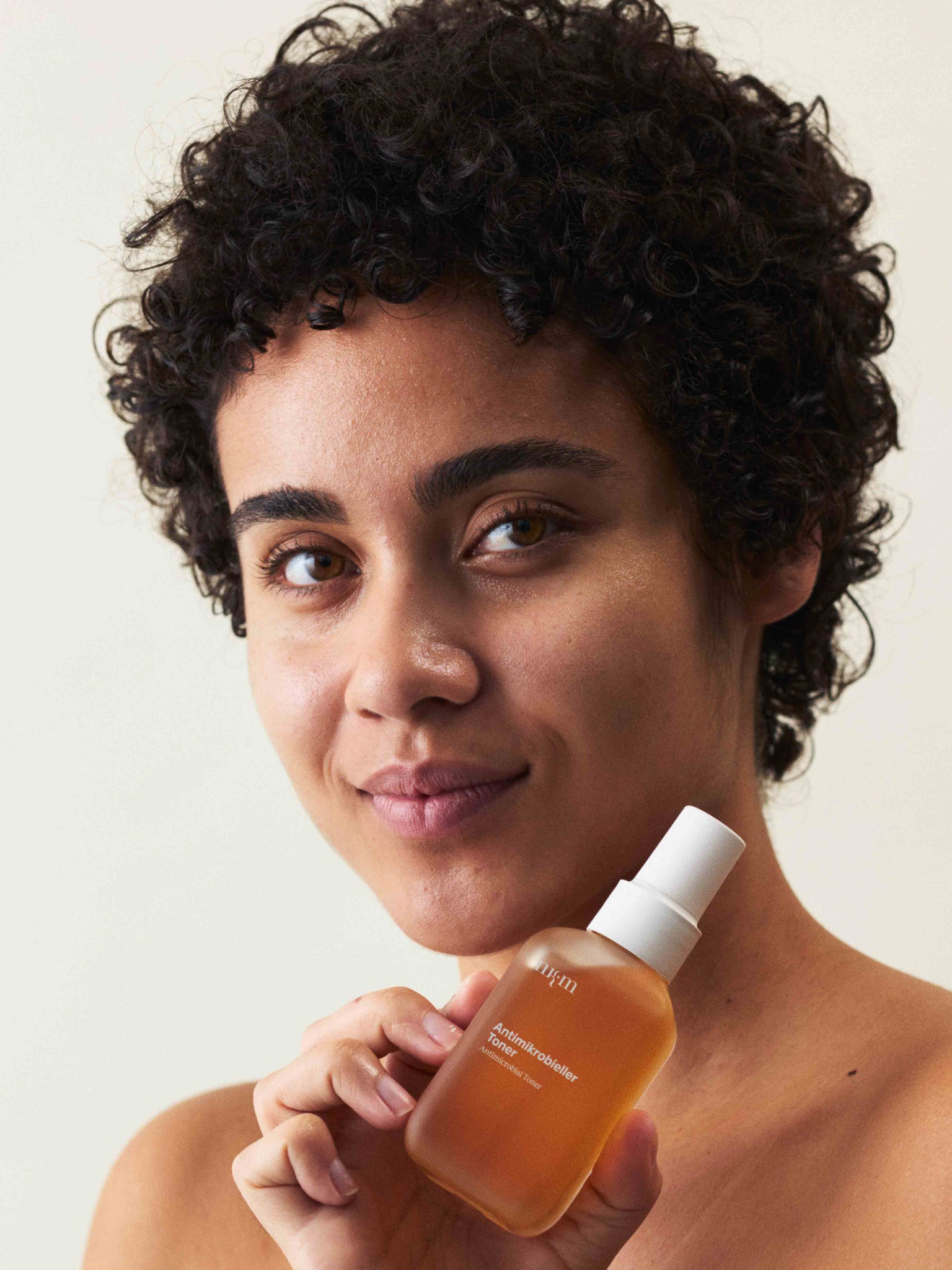 Eine Frau, die den Antimikrobiellen Toner der Hand hält