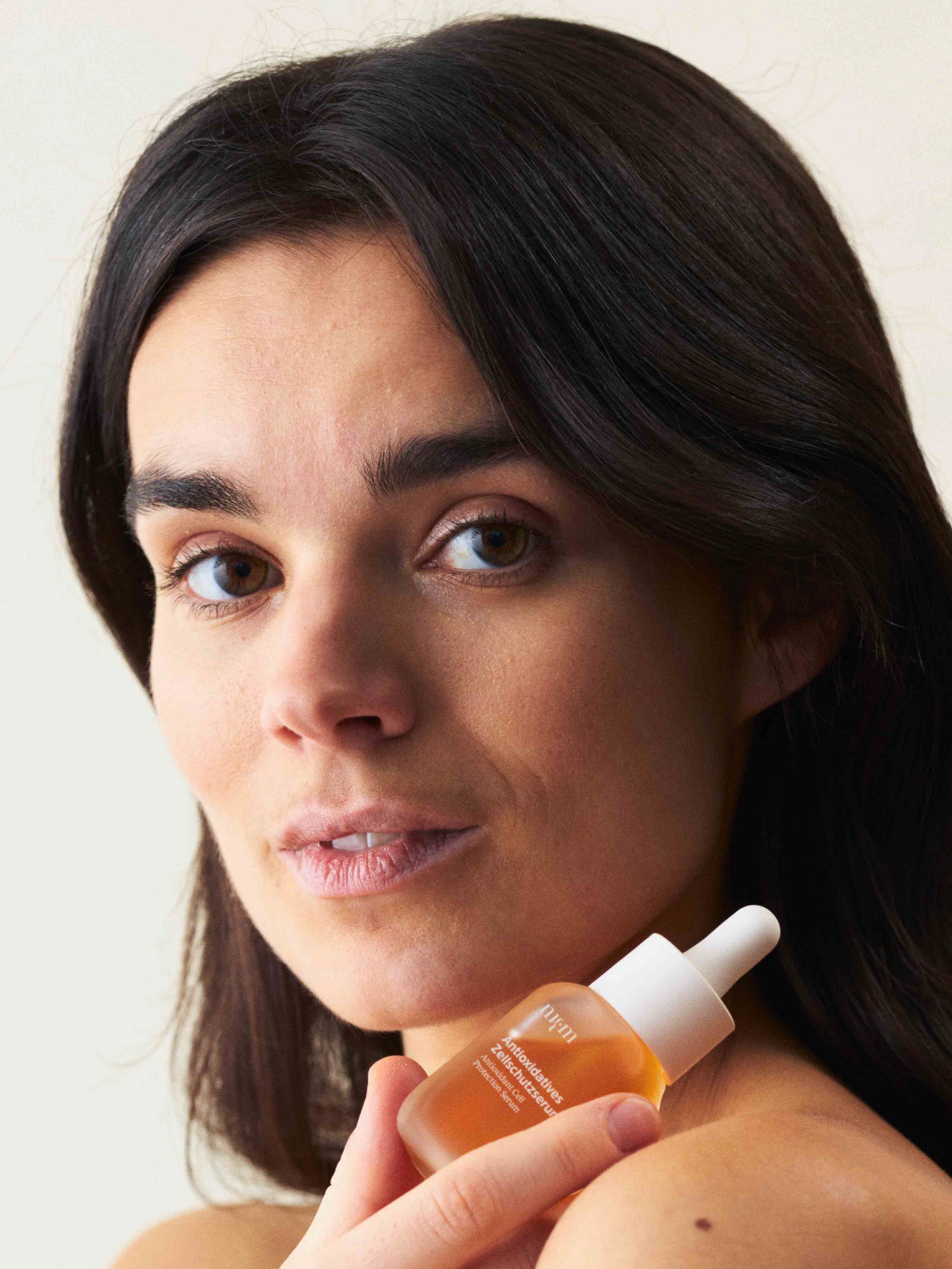 Eine Frau, die das Antioxidative Zellschutzserum in der Hand hält