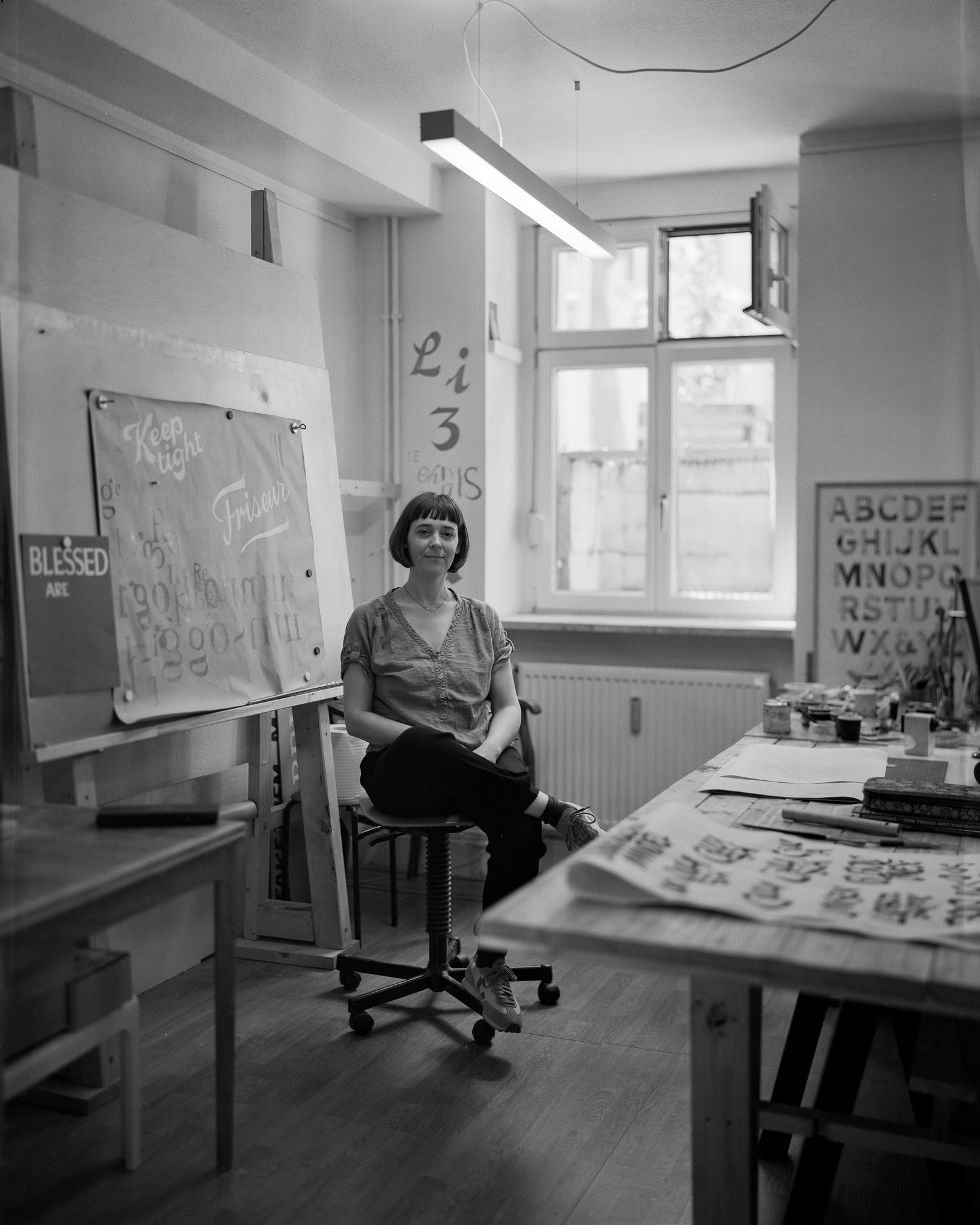 Frau sitzt auf Stuhl in schwarz-weiß