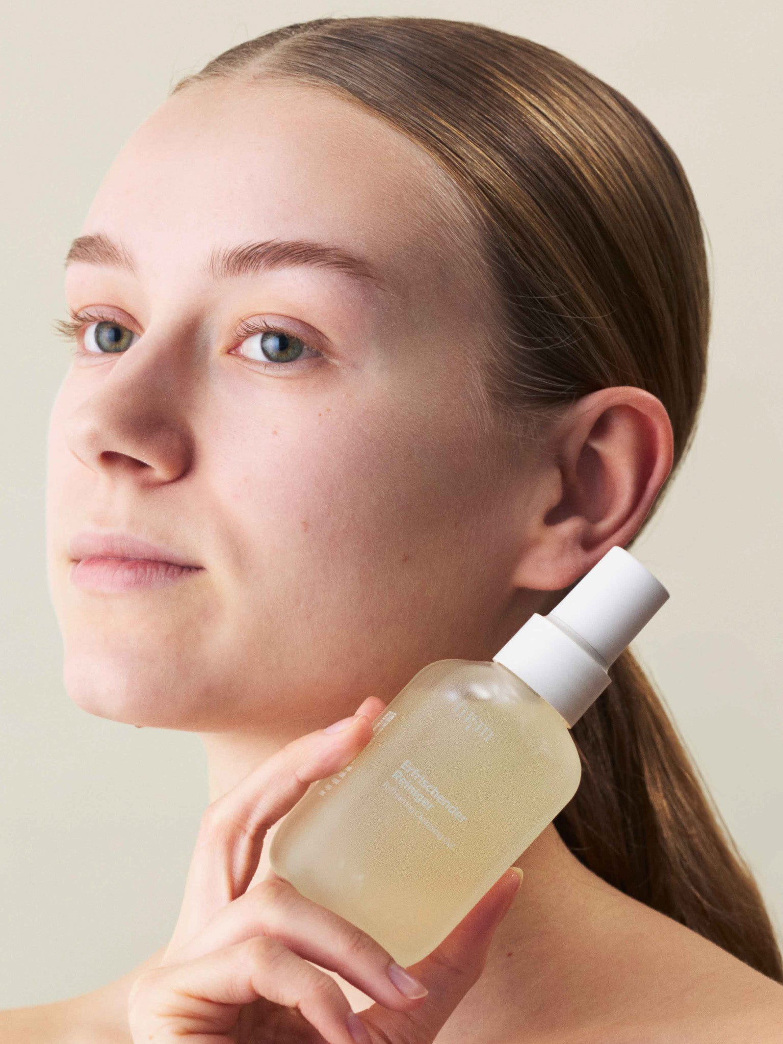 Eine Frau, die den Erfrischenden Reiniger in der Hand hält