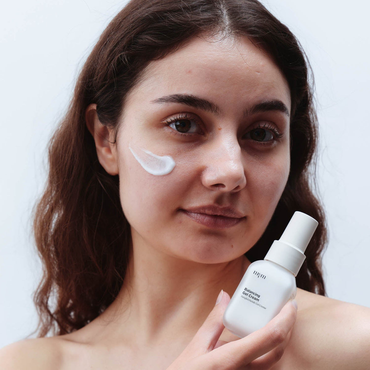 Frau mit dunklen Haaren hält Balancing Gel Cream in der Hand