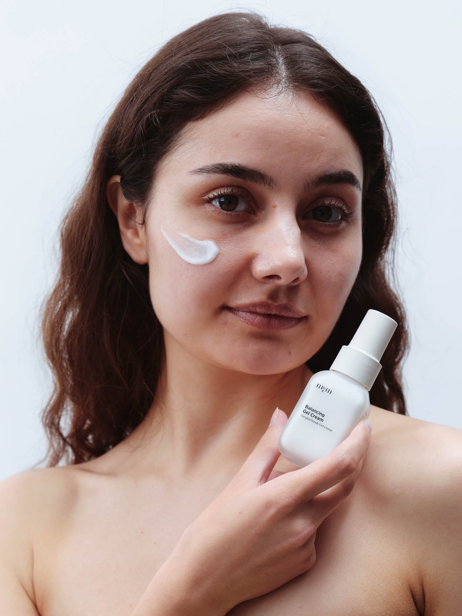 Frau mit dunklen Haaren hält Balancing Gel Cream in der Hand
