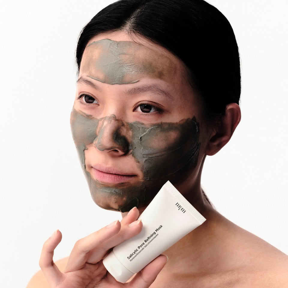 Frau mit Salicylic Pore Refining Mask aufgetragen im Gesicht. Sie hält die Tube in der Hand