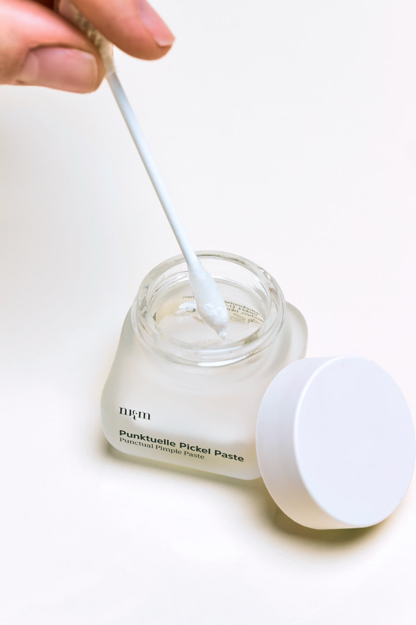Punktuelle Pickel Paste von nkm wird mit einem Wattestäbchen aufgetragen