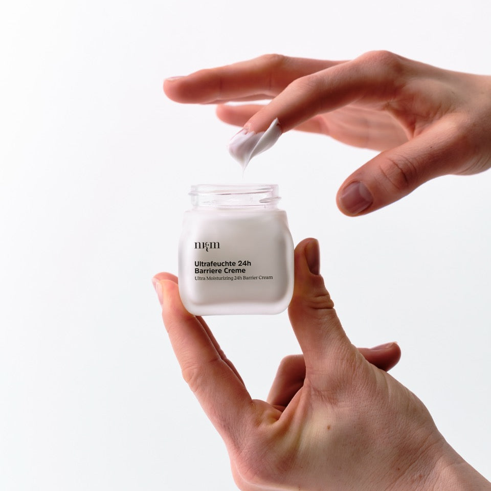 Finger tunkt in die Ultrafeuchte 24h Barriere Creme von nkm