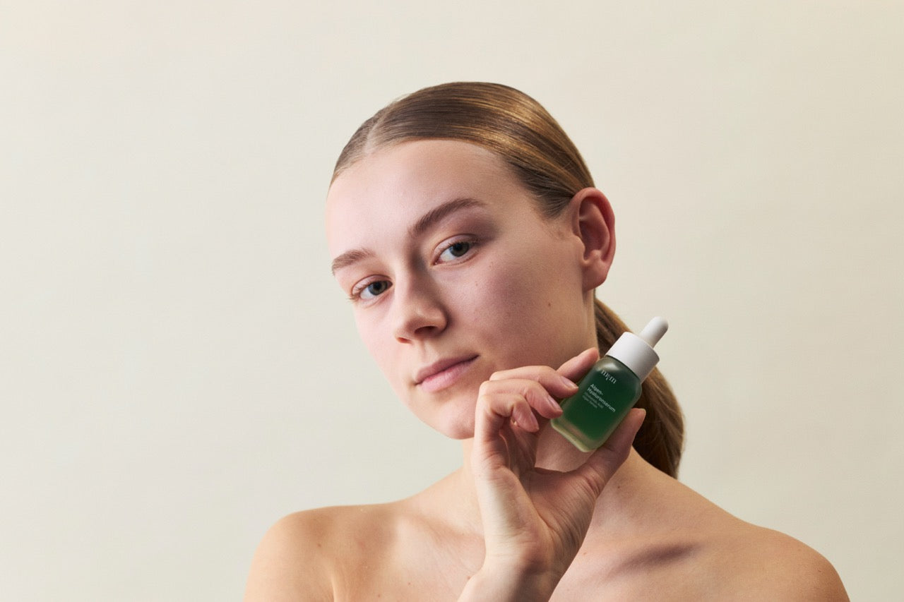 Frau hält das Algen-Hyaluronserum von nkm in der Hand