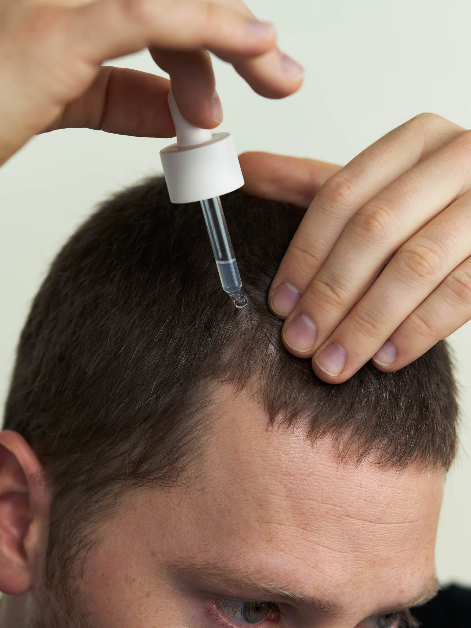 Das Kopfhautserum von nkm wird mit der Pipette auf die Kopfhaut gegeben