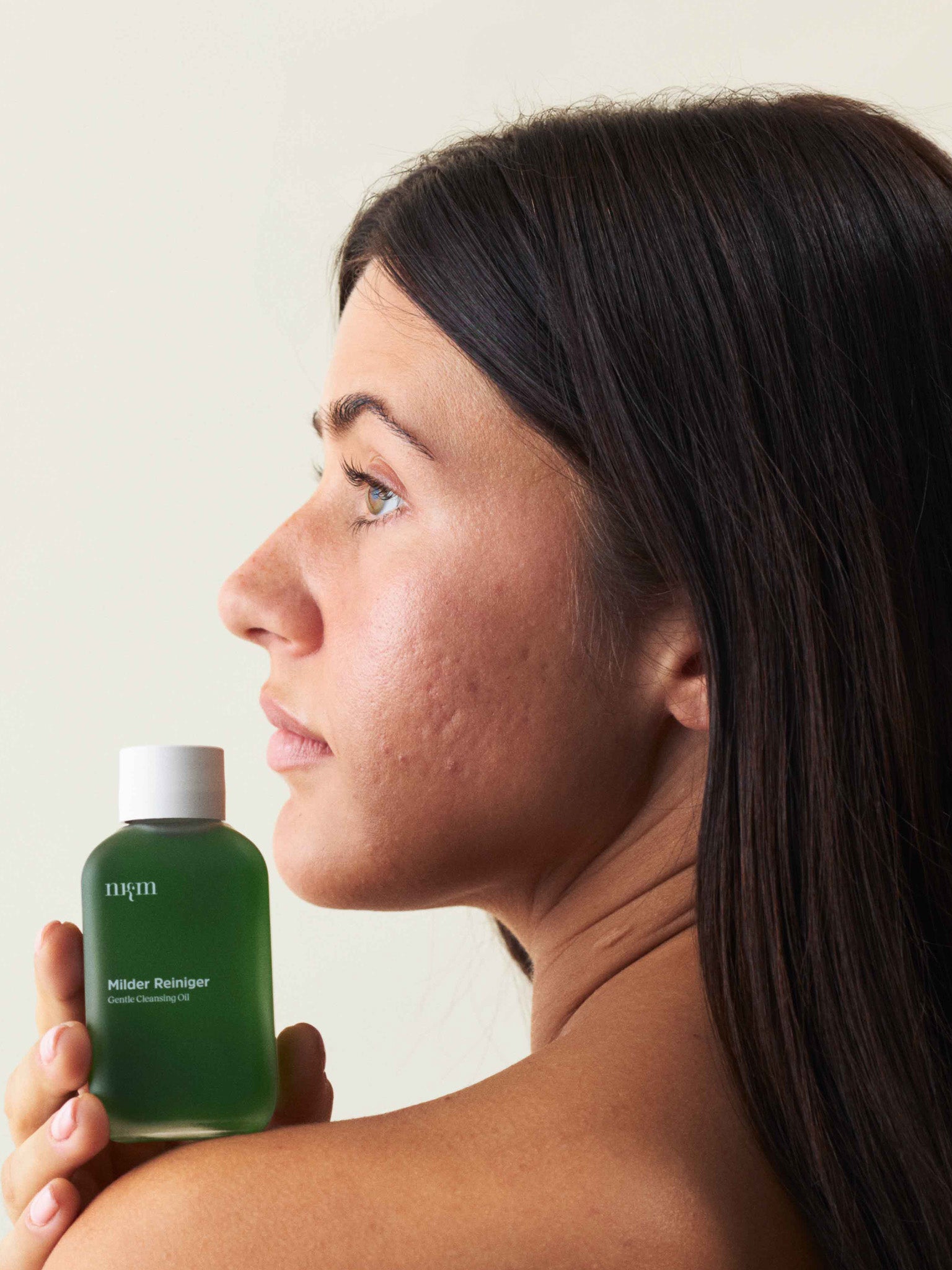 Eine Frau, die den Milden Reiniger in der Hand hält