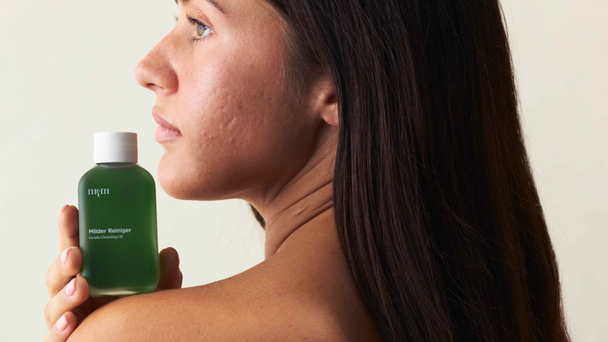 Eine Frau, die nach links schaut und den Milden Reiniger auf ihrer Schulter ablegt