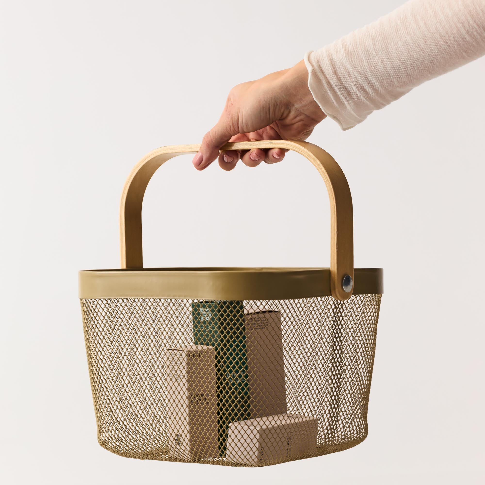 Hand hält einen Einkaufskorb gefüllt mit nkm Produkten