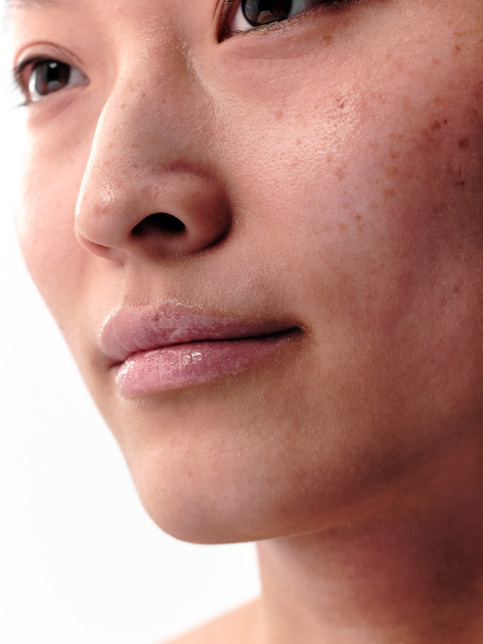 Close up von Gesicht einer Frau mit Fokus auf gepflegten, glänzenden Lippen