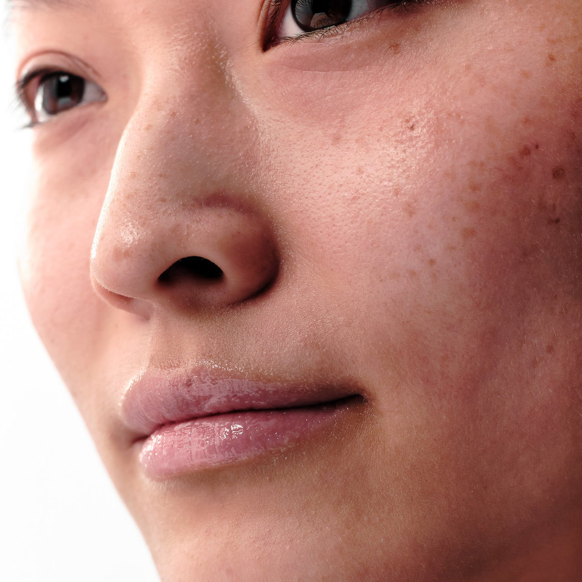 Close up von Gesicht einer Frau mit Fokus auf gepflegten, glänzenden Lippen
