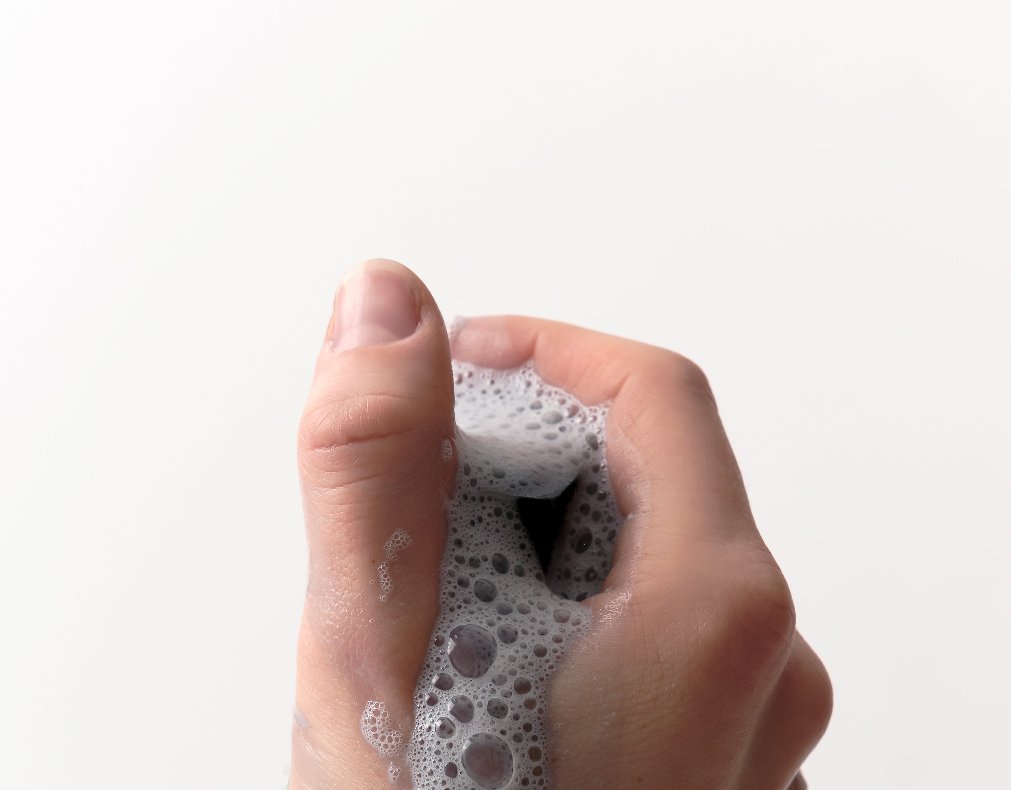 Hand, die schäumenden Reinigungsblock hält