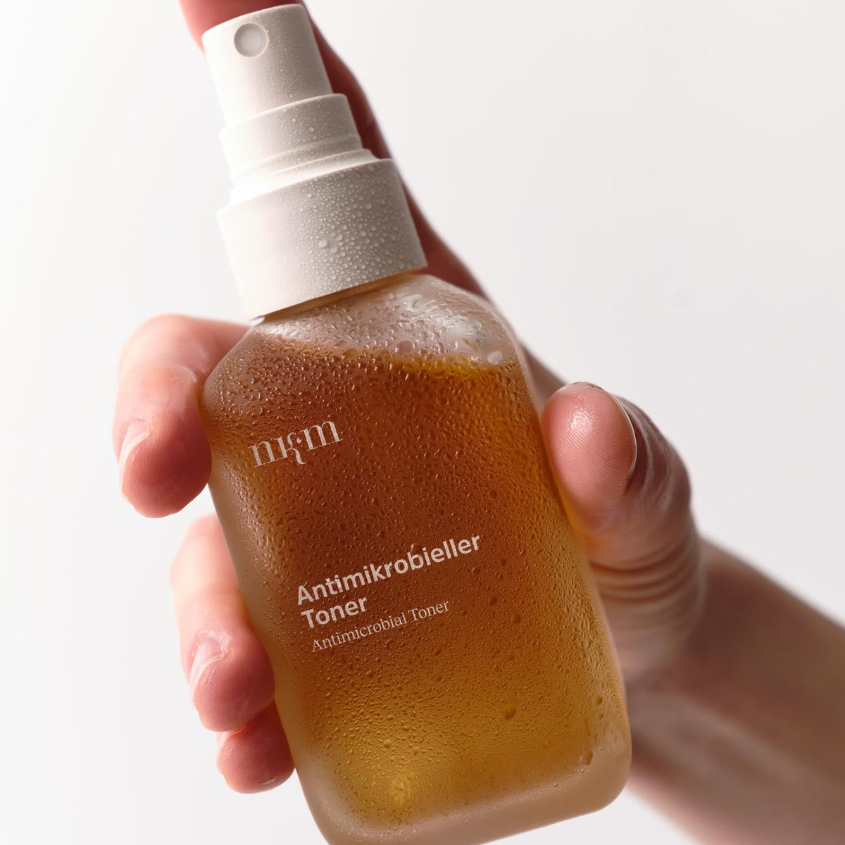 Hand hält Antimikrobiellen Toner von nkm