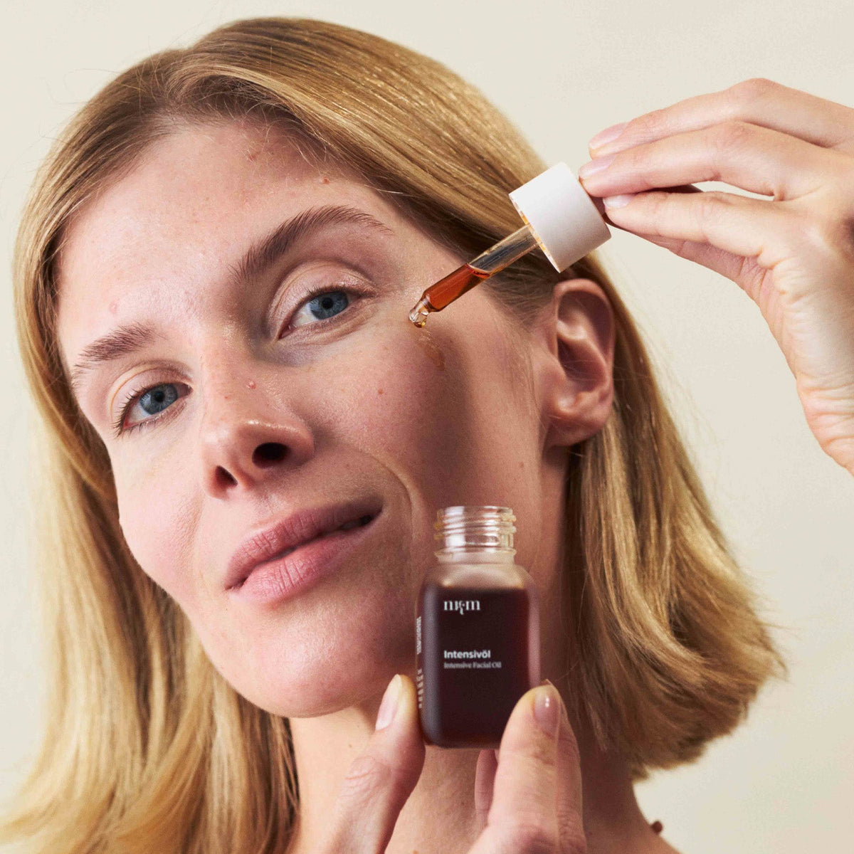 Eine Frau, die das Intensivöl in der Hand hält