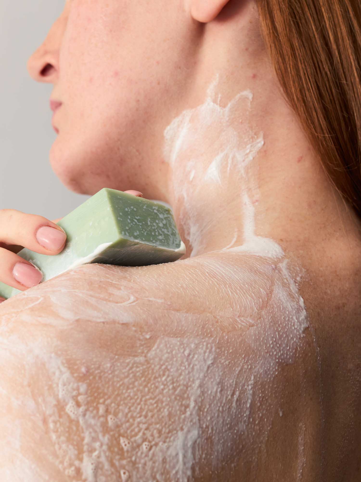 Nahaufnahmen von eine Frau, die ihren Kopf gedreht hat und ihre Schultern einschäumt