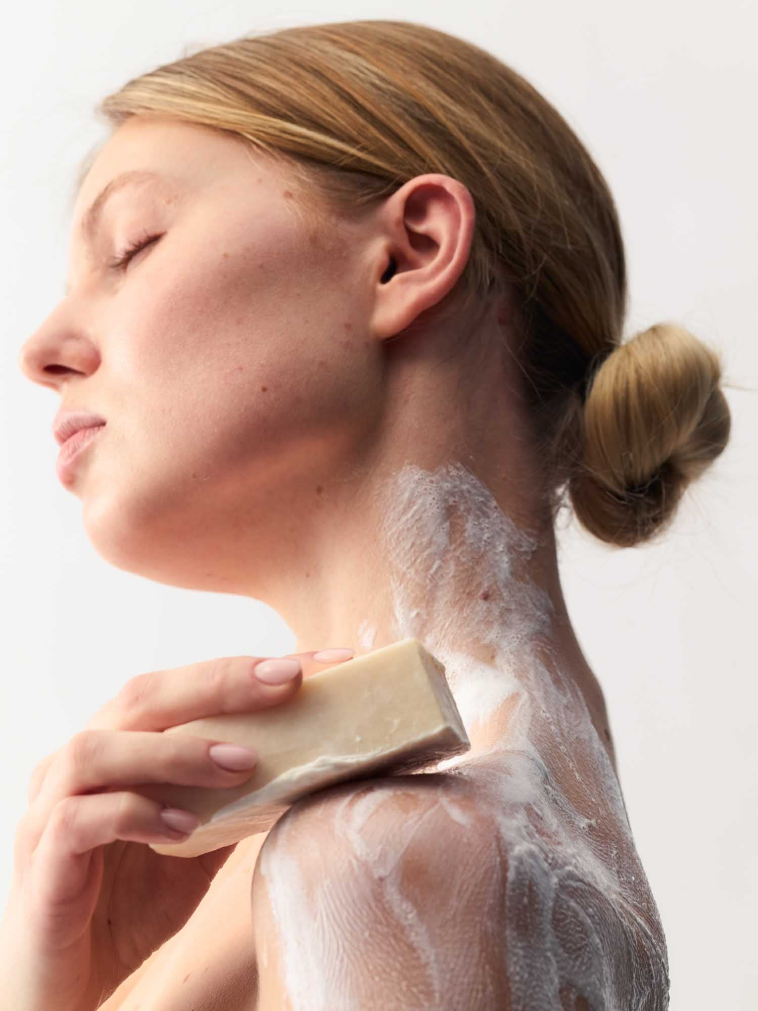 Eine Frau, die ihren Kopf gedreht hat und ihre Schultern einschäumt