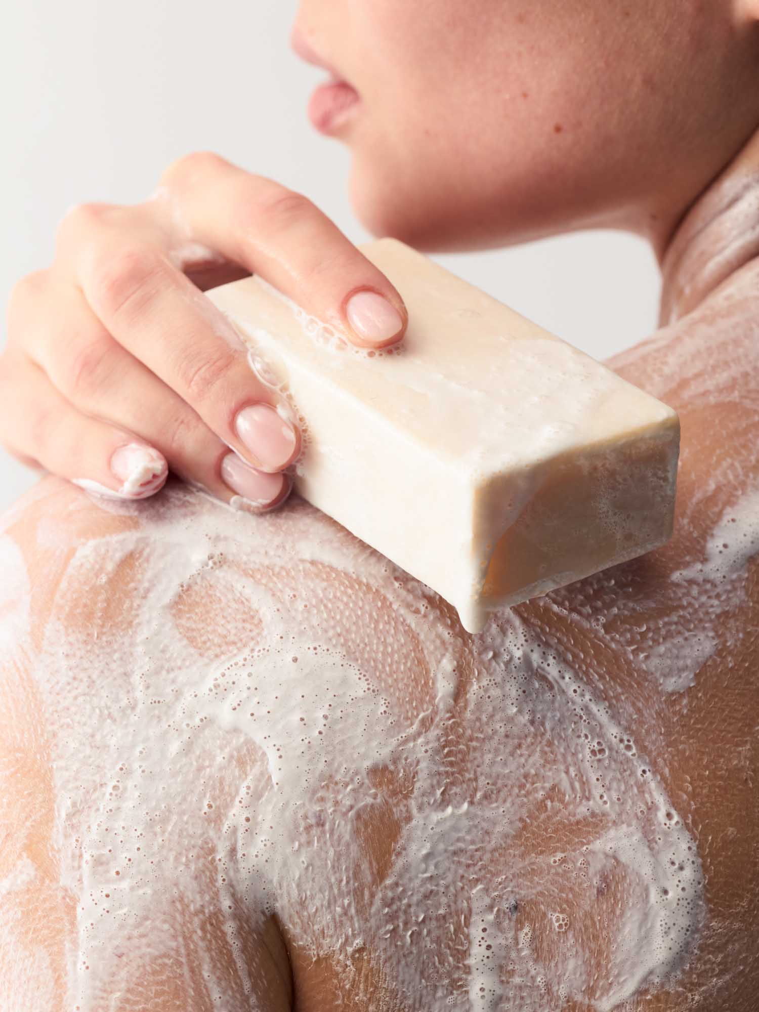 Eine Frau, die ihren Kopf gedreht hat und ihre Schultern einschäumt