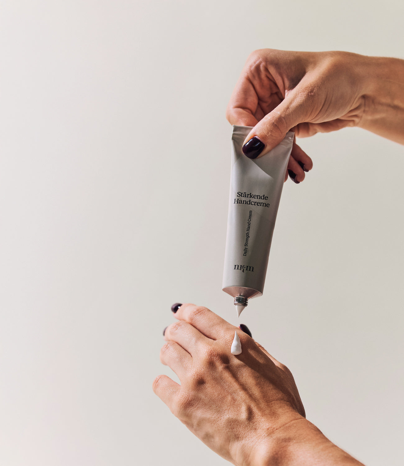 Handcreme wird aus einer Tube gedrückt und auf die Hand aufgetragen