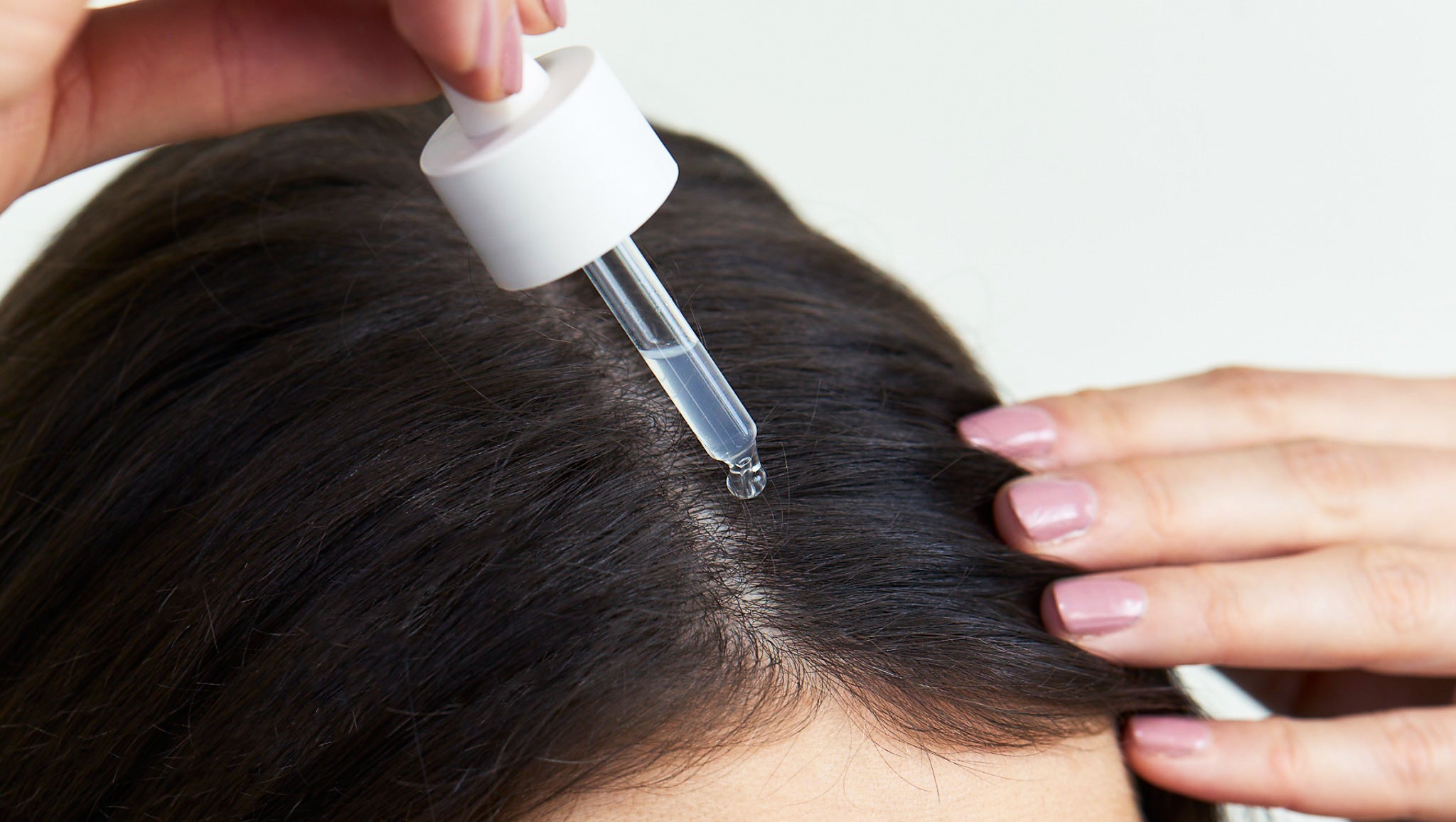 Das Kopfhautserum von nkm wird mit der Pipette auf die Kopfhaut gegeben