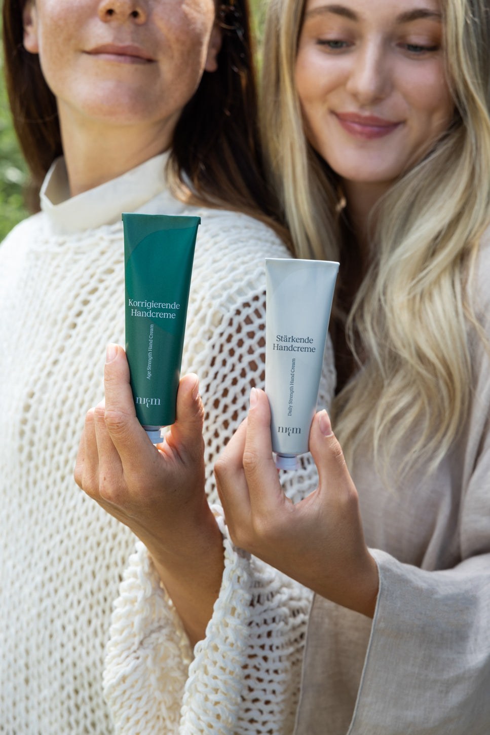 Zwei Frauenmodels halten die nkm Handcremes