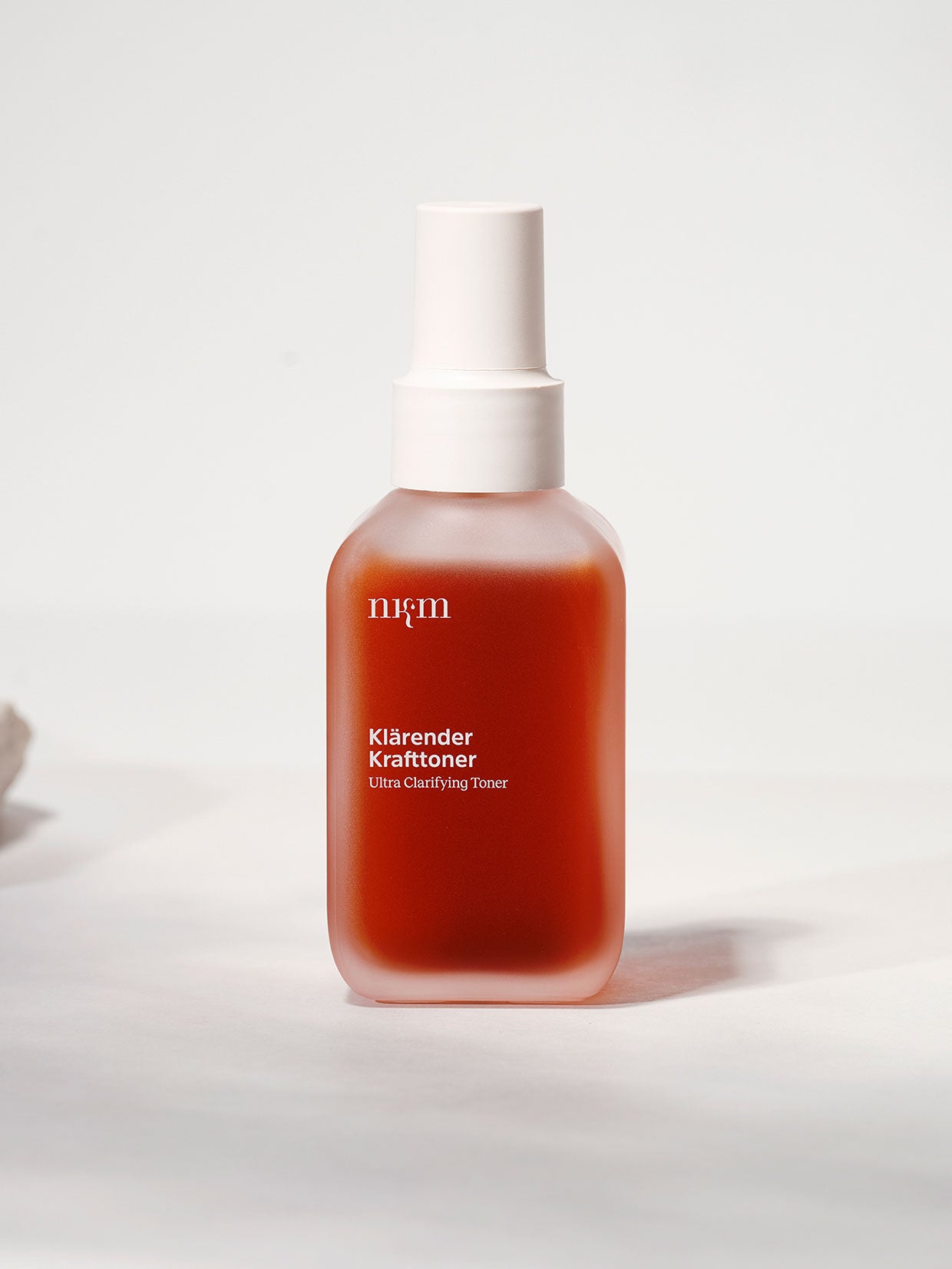 Milchglasflasche der nkm Naturkosmetik München GmbH Klärender Krafttoner mit weißem Pumpverschluss, formuliert mit Niacinamid zur Regulierung der Talgproduktion und zur Verbesserung unreiner Haut.