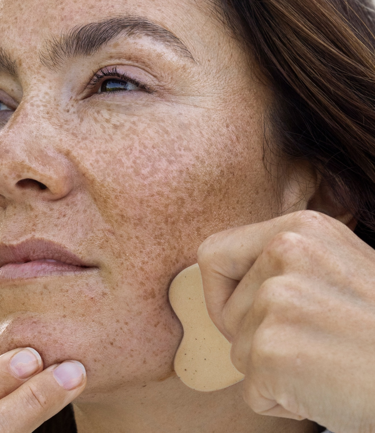 Eine Frau, die den Gua Sha anwendet