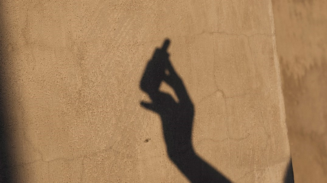 Schatten einer Hand die ein Serum hält