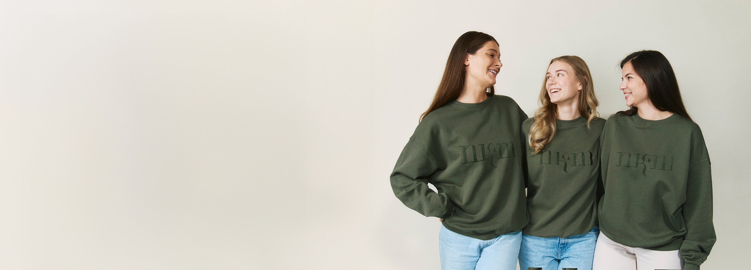 Drei Personen, die sich anschauen und einen nkm Sweater tragen.