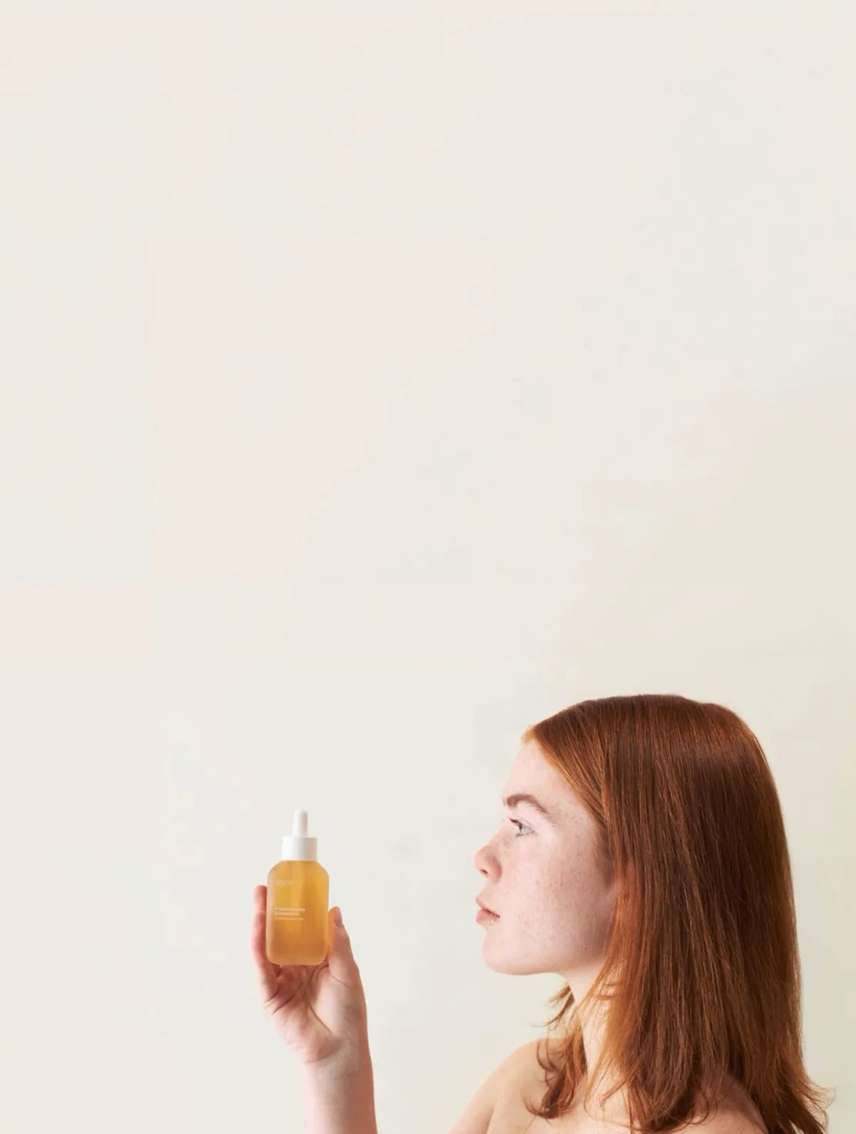 Eine Frau mit sensibler Haut, die ein nkm Produkt in der Hand hält.