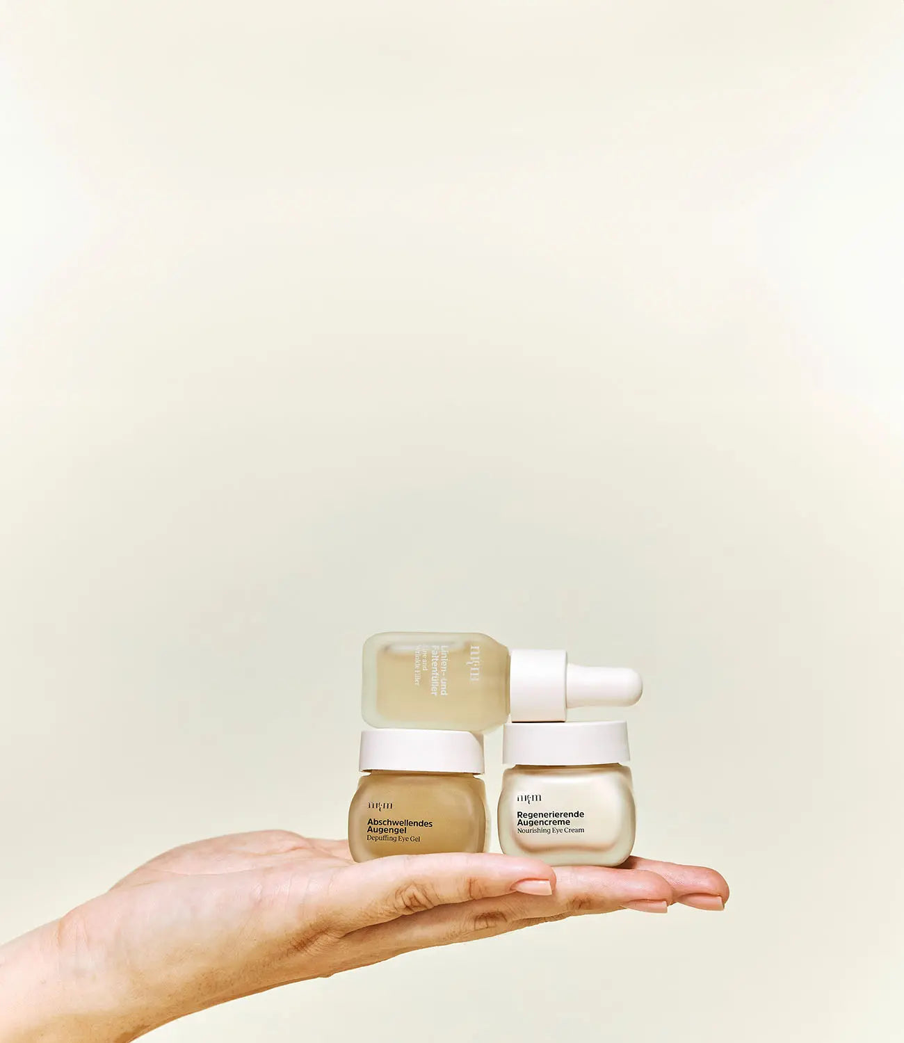 Linien- und Faltenfüller, Abschwellendes Augengel und Regenerierende Augencreme auf flacher Hand gelegt
