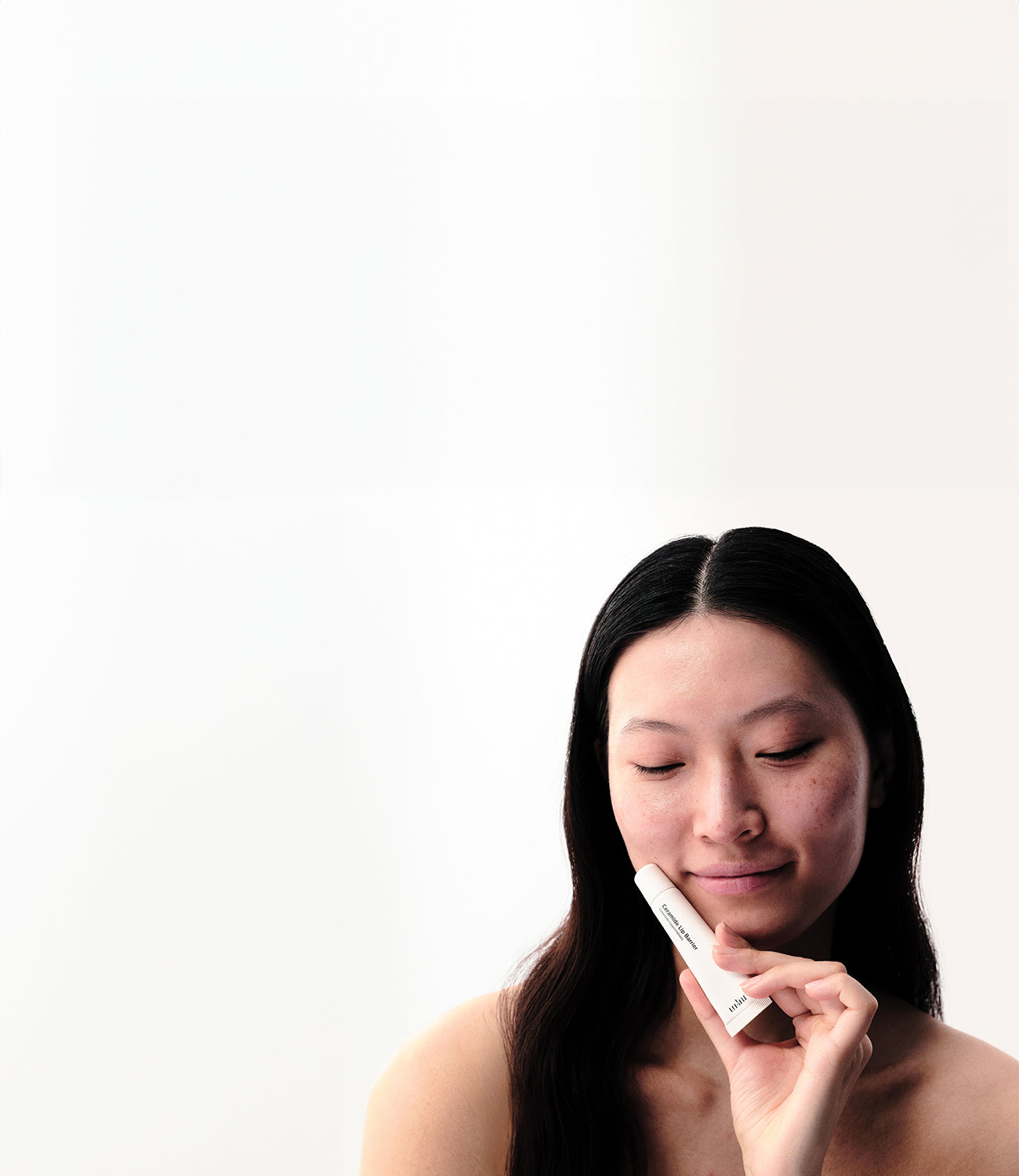 Frau hält Ceramide Lip Barrier