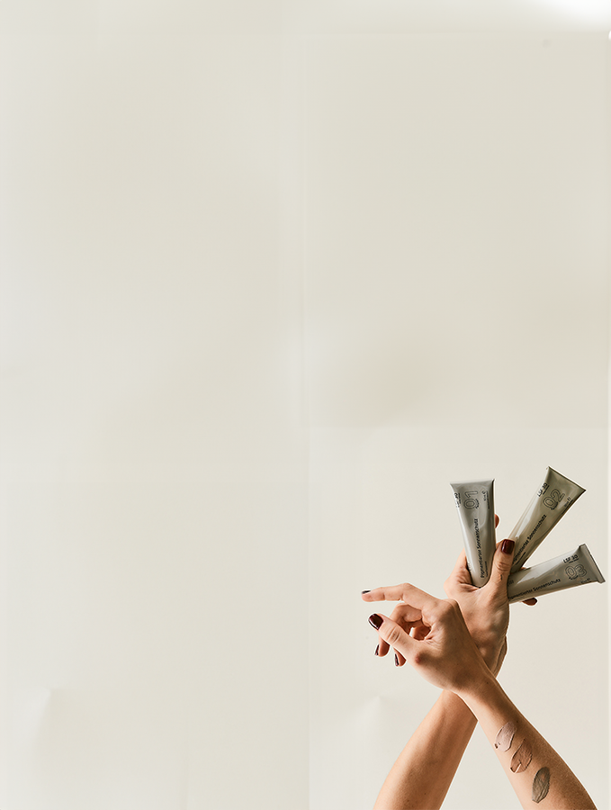 Hand hält alle drei Pigmentierten Sonnenschutze in einer Hand, auf der anderen Hand sind die Sonnenschutze aufgetragen