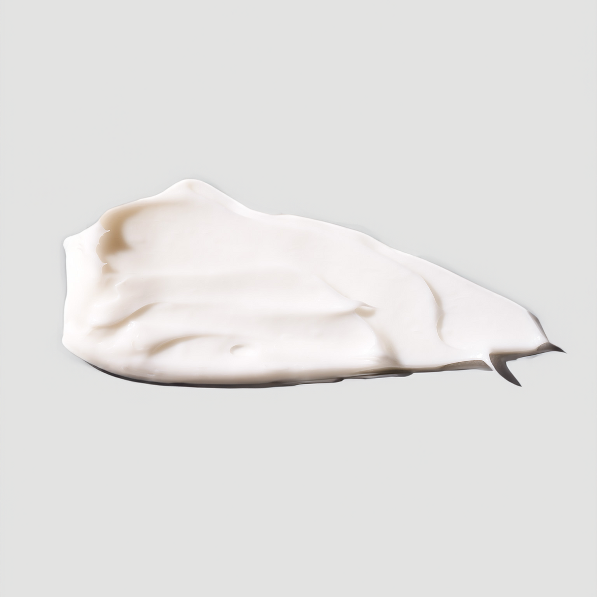 Ein Abstrich der weißen Ultrafeuchte 24h Barriere Creme der nkm Naturkosmetik München GmbH, die Niacinamid und Ceramiden enthält, auf hellgrauem Grund.