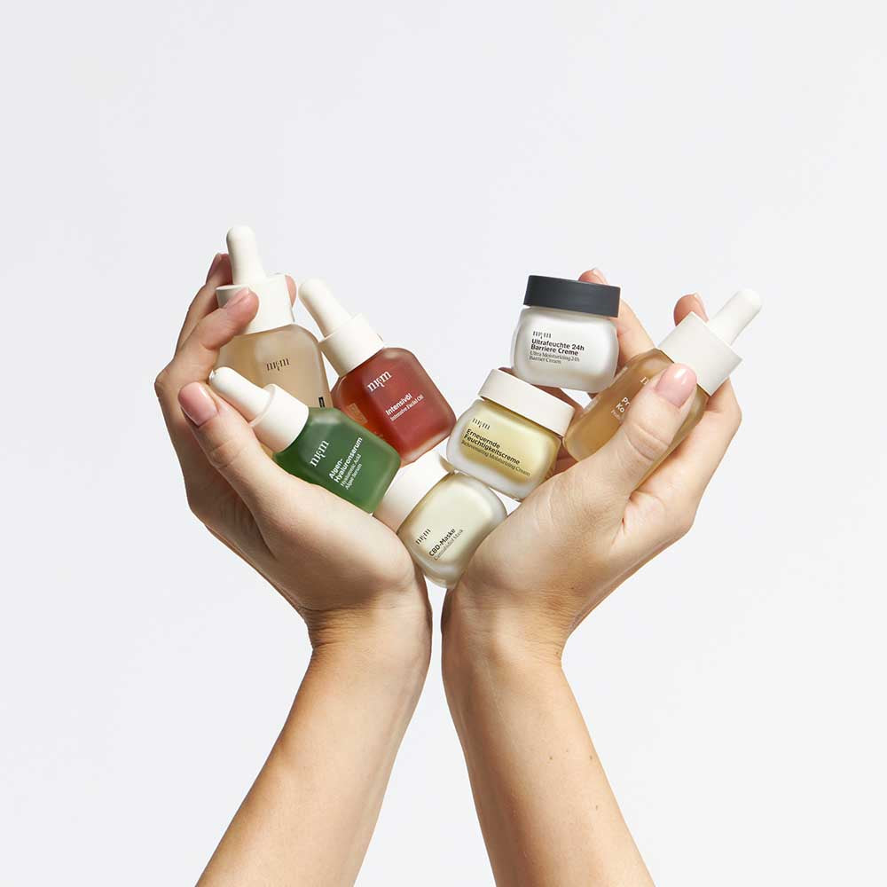 Zwei Hände, die verschiedene Reisegrößen in der Hand halten