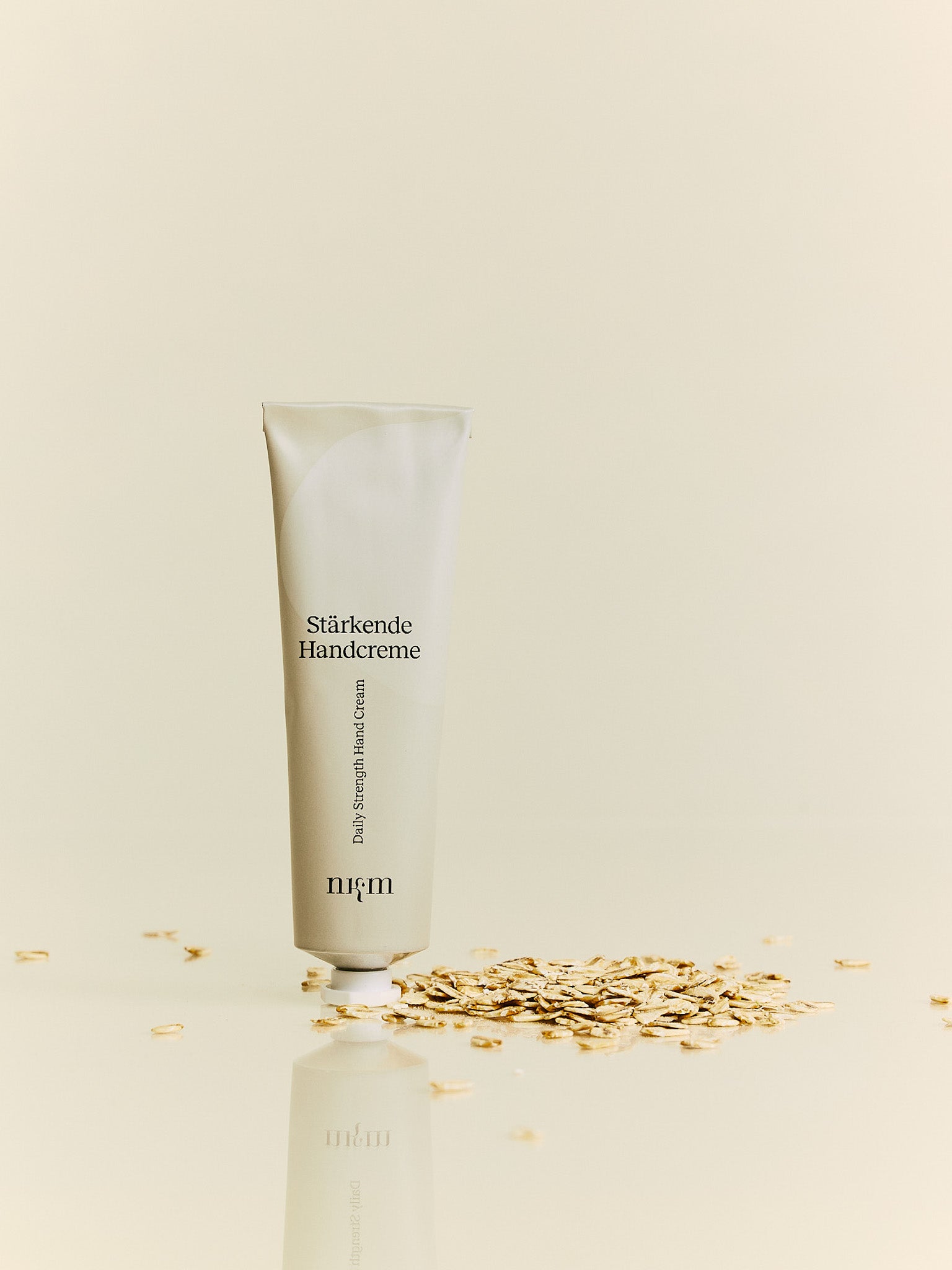 Stärkende Handcreme Tube von nkm daneben liegen Haferflocken
