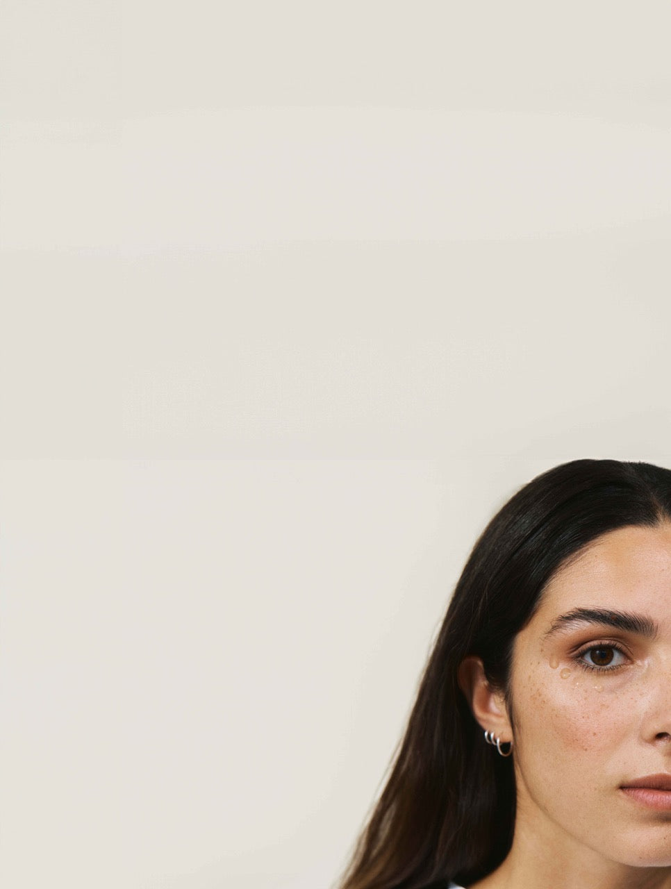 Frau mit dunklen Haaren und aufgetragenem Augengel