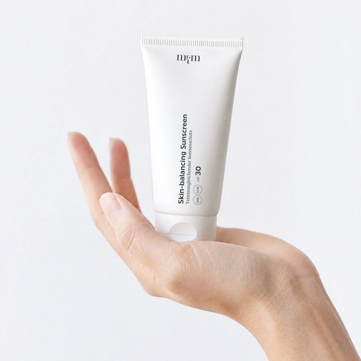 Eine Hand hält die Skin-balancing Sunscreen
