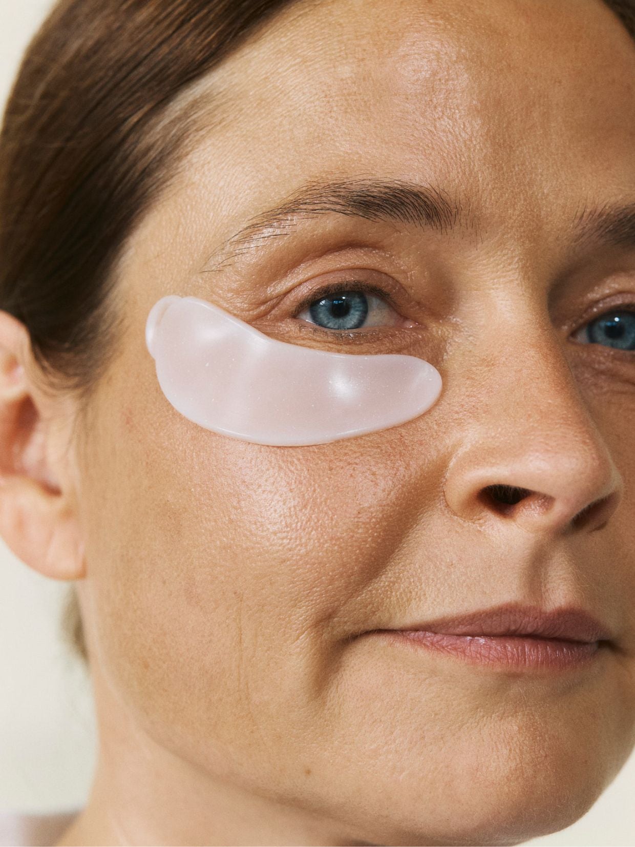 Eine Frau mit reifer Haut trägt die wiederverwendbaren nkm Augenpads