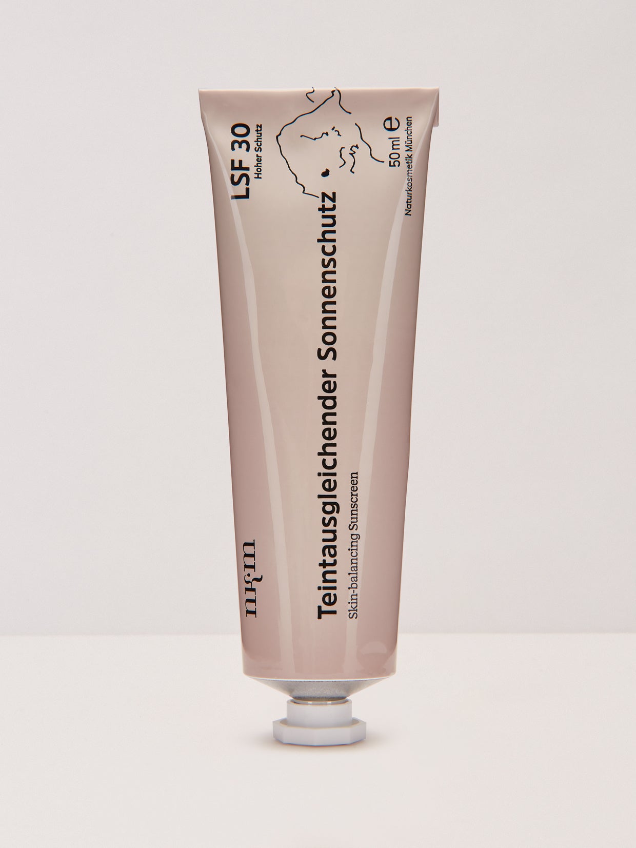 Eine beigefarbene Tube des Teintausgleichenden Sonnenschutzes LSF 30 der nkm Naturkosmetik München GmbH mit deutschem Text und Zink steht aufrecht auf einer weißen Fläche.
