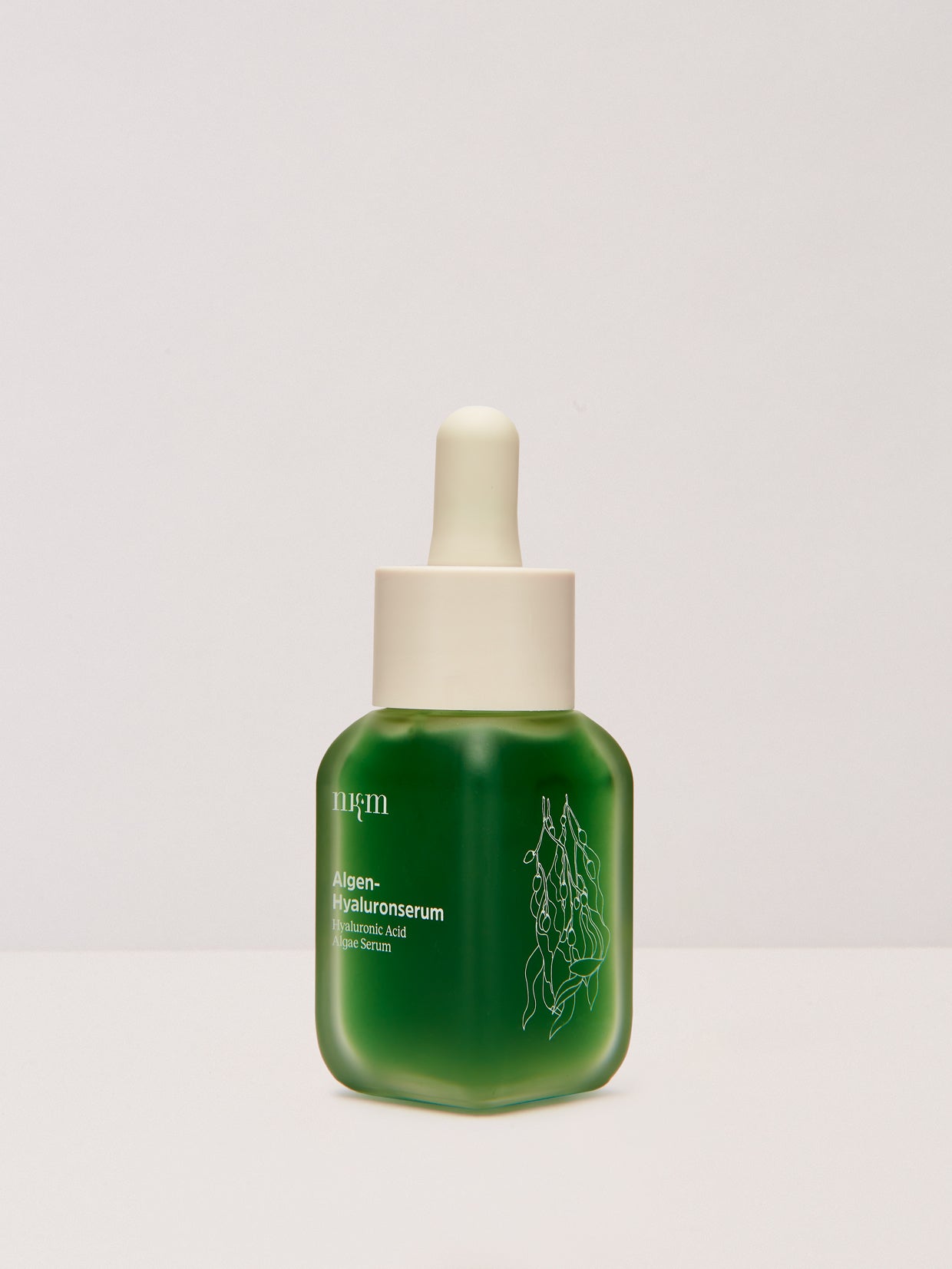 Eine grüne Tropfflasche von nkm Naturkosmetik München GmbH Algen-Hyaluronserum mit weißem Text und Abbildungen, die Seetang-Extrakt zur Unterstützung der Hautelastizität enthält, dargestellt auf einem schlichten weißen Hintergrund.