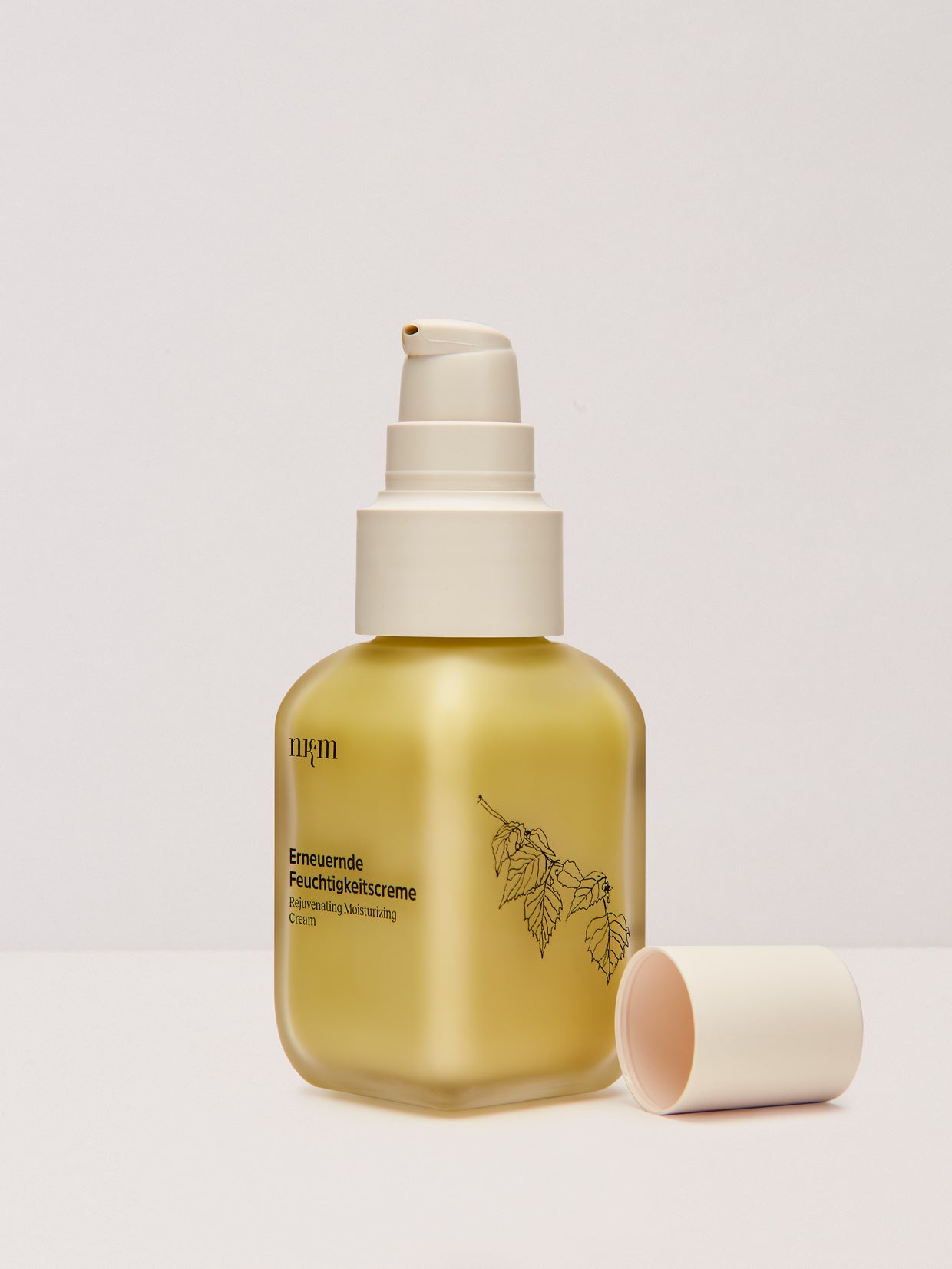 Die Erneuernde Feuchtigkeitscreme der nkm Naturkosmetik München GmbH ist in einer goldenen Flasche mit Pumpspender und weißem Verschluss erhältlich und eignet sich perfekt für die Feuchtigkeitsversorgung und Hautpflege.