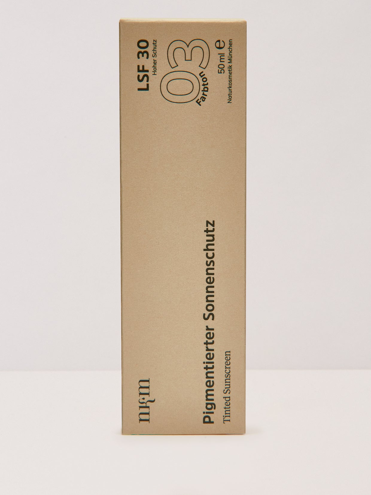 Eine hohe, beigefarbene Schachtel von nkm Naturkosmetik München GmbH Pigmentierter Sonnenschutz Farbton 3 (dunkel) SPF 30 (50ml) mit deutschem und englischem Text. Enthält Zink und Squalan für verbesserten Schutz und Pflege der Haut.