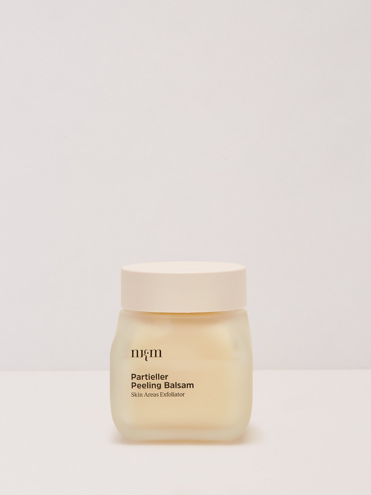 Ein gefrosteter Tiegel mit der Aufschrift Gestärkte Hände Duo von nkm Naturkosmetik München GmbH und einem beigen Deckel steht auf einem schlichten Hintergrund - zur Unterstützung des Hautmikrobioms.