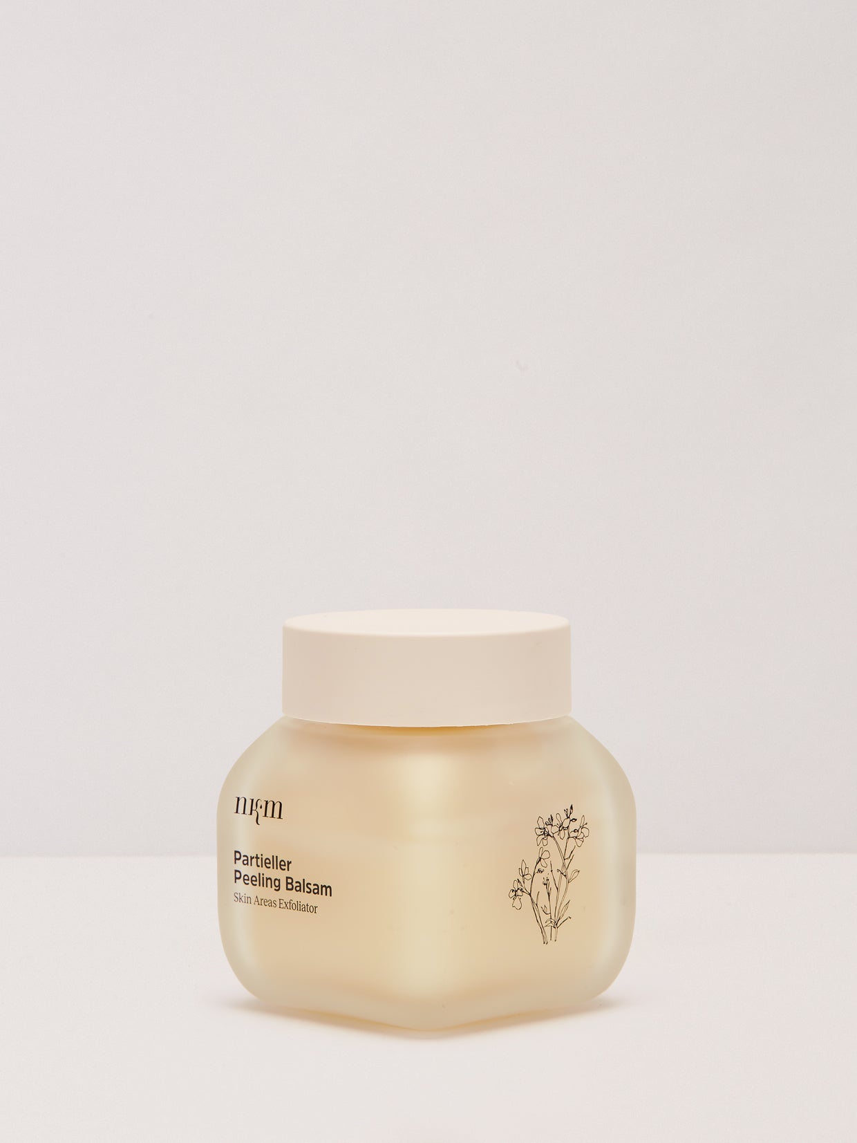 Ein gefrosteter Tiegel von Regenerierte Hände Trio der nkm Naturkosmetik München GmbH mit weißem Deckel steht auf einem schlichten Untergrund, ideal gegen Hautalterung und in Kombination mit Ihrer Lieblings-Handcreme.