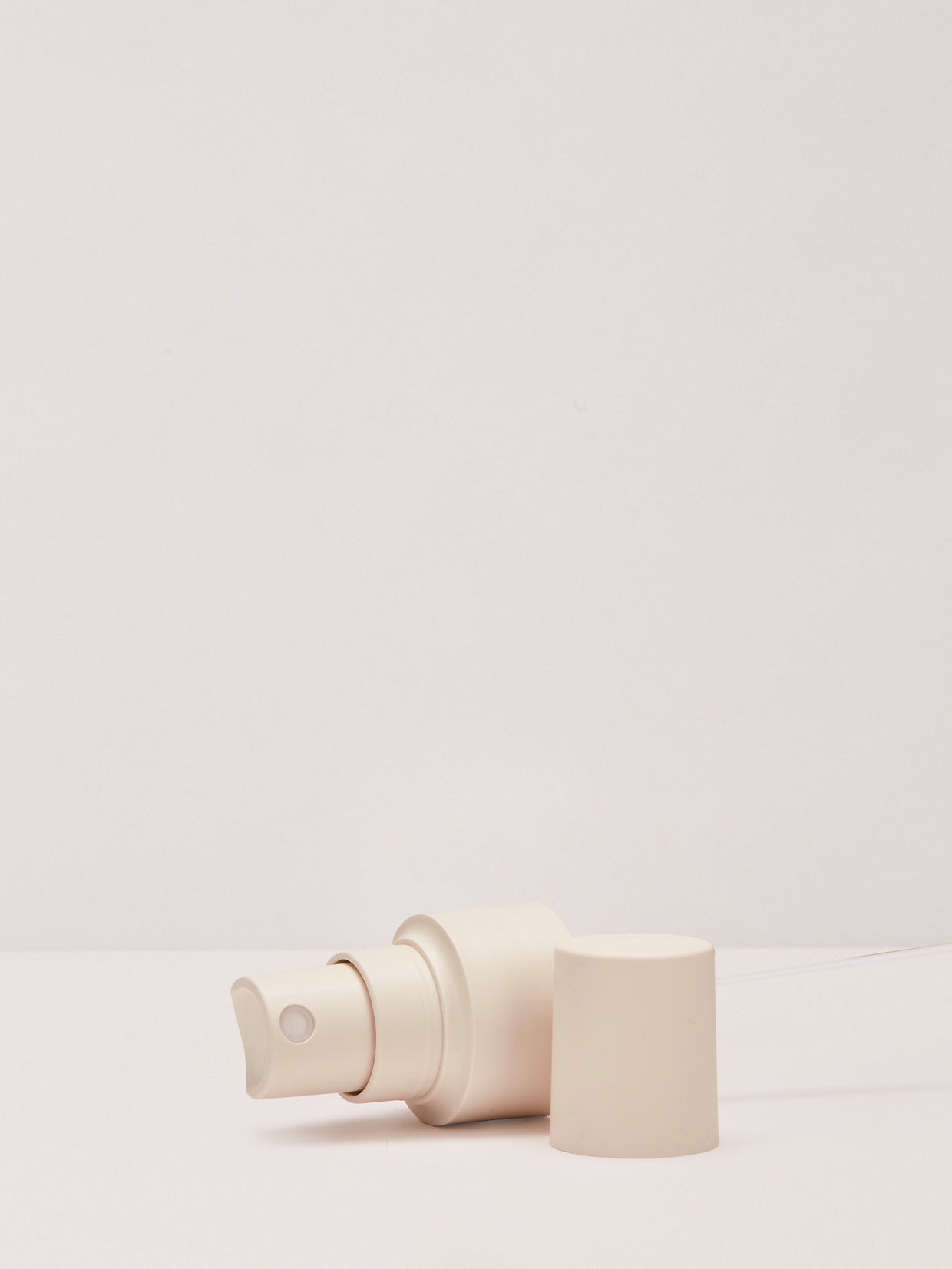 Der Sprühaufsatz hell für 100 ml von nkm Naturkosmetik München GmbH, hier unverschlossen auf einer weißen Fläche, ist perfekt für Mehrwegflaschen und aus Monomaterial für einfaches Recycling.