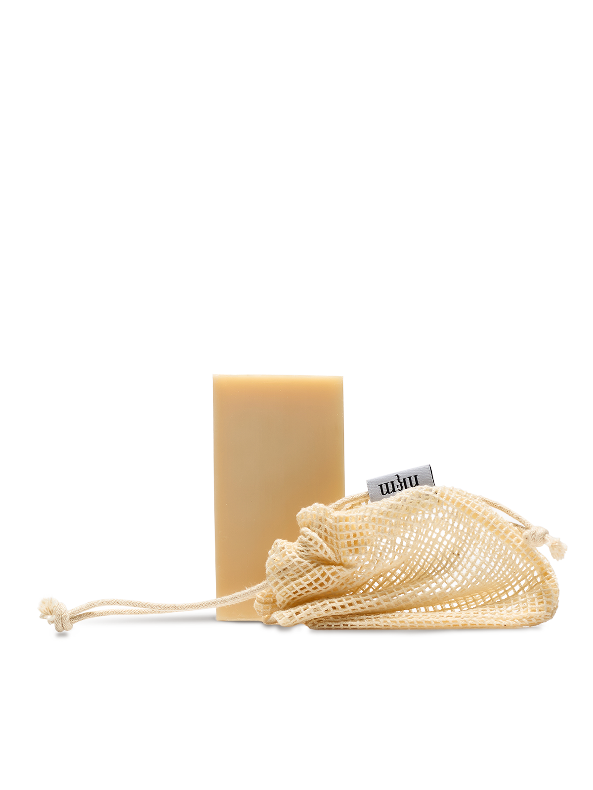 Beruhigender Reinigungsblock, davor liegt ein Baumwollnetz mit nkm Etikett, vor transparentem Hintergrund